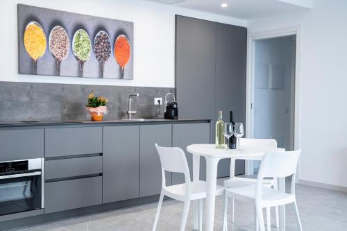 a kitchen with a white table and white chairs at Appartamento Guglielmo in Oristano