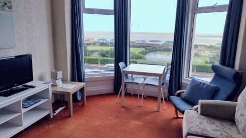 a living room with a television and a table and chairs at The Kathrene in Fleetwood