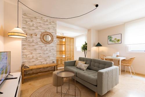 uma sala de estar com um sofá e uma mesa em Teatro Suites Málaga CITY FLAT em Málaga