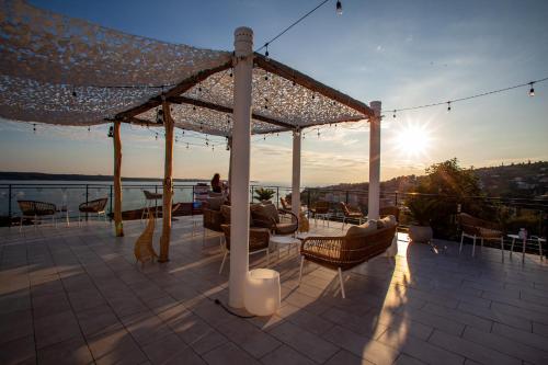a patio with a table and chairs and the sun at Villa Bellevue Portoroz-Portorose in Portorož