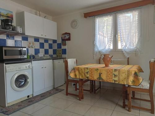 une cuisine avec une table et une machine à laver dans l'établissement la cigogne, à Céret