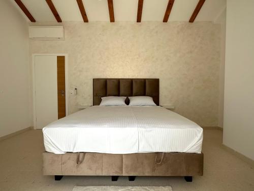 a bedroom with a large bed with white sheets at Orebic Luxury Villa Leopold in Orebić