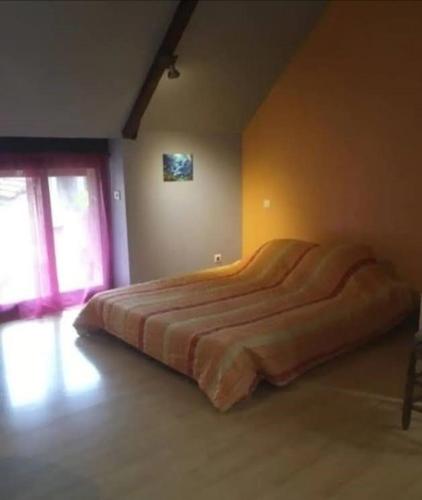 une chambre avec un grand lit dans une pièce dans l'établissement Chambre chez l'habitant, à Rueyre