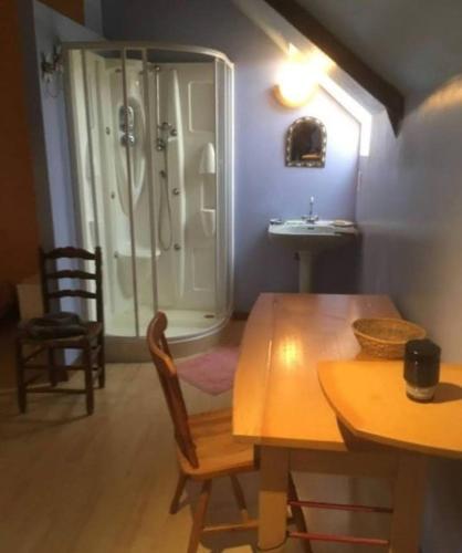 La salle de bains est pourvue d'une table, d'une douche et d'un lavabo. dans l'établissement Chambre chez l'habitant, à Rueyre