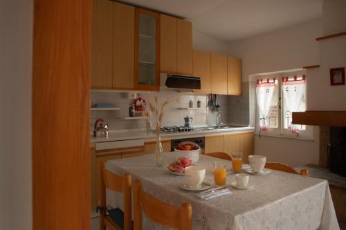 a kitchen with a table with a bowl of fruit on it at La Casa del Gelsomino in Acquaviva Picena
