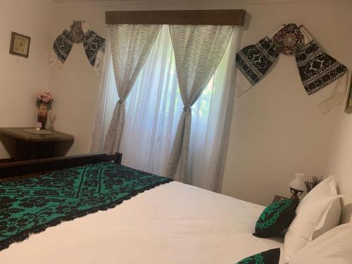a bedroom with a bed and a window at CASA LUI MOȘU in Alba Iulia