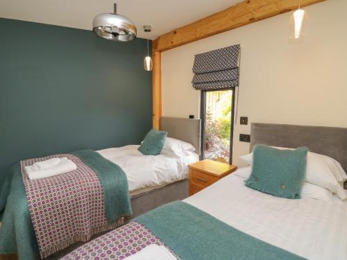 a bedroom with two beds and a window at Celyn in Welshpool