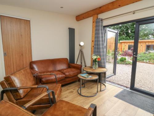 a living room with a leather couch and a table at Pansi in Welshpool