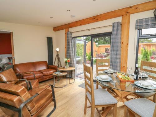 a living room with a glass table and chairs at Pansi in Welshpool