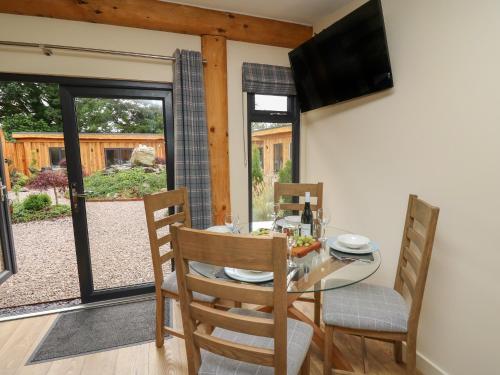 a dining room with a table and chairs and a television at Pansi in Welshpool
