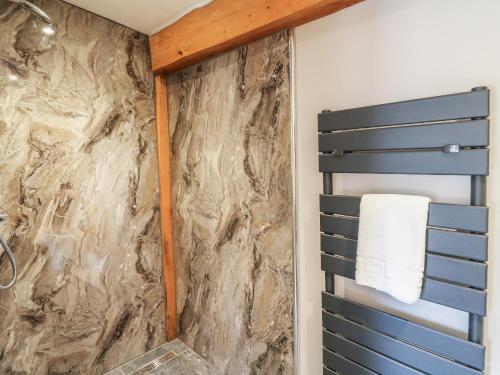 a bathroom with a stone wall at Pansi in Welshpool