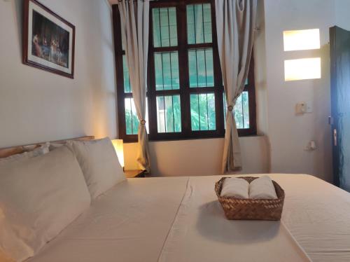a bedroom with a bed with a basket on it at HOTEL NIETO MOMPOX, ubicado en el corazón del centro histórico, frente al rio magdalena en zona de malecón in Mompos