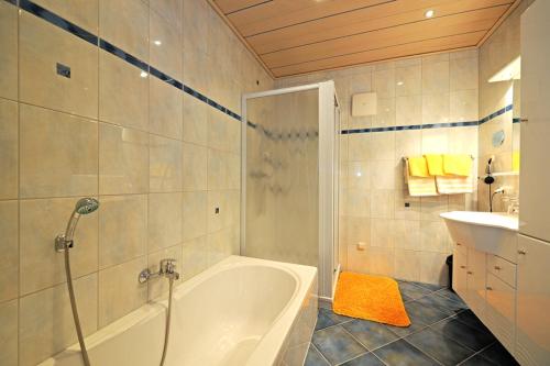 a bathroom with a tub and a sink at Sauschneid Hof in Taxenbach