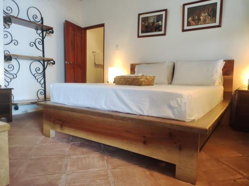 a bedroom with a large bed with a wooden frame at HOTEL NIETO MOMPOX, ubicado en el corazón del centro histórico, frente al rio magdalena en zona de malecón in Mompos