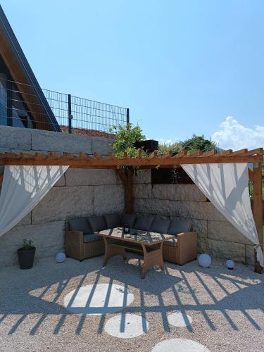 a patio with a couch and a table on a building at Stone Chalets - TERRA in Jajce