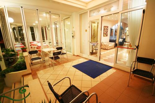 a room with a balcony with chairs and a table at Hotel Cheri in Rimini