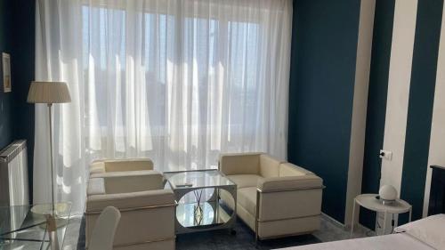 uma sala de estar com duas cadeiras e uma mesa de vidro em Stupenda camera vista mare con finiture di lusso em Marina di Carrara