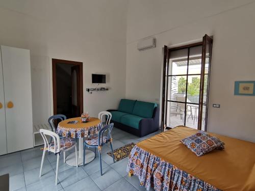 a bedroom with a bed and a table and a couch at Tuttiacasaditeresa Rooms in Procida