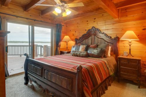 a bedroom with a large bed in a log cabin at Lakefront Langley Retreat with Decks and Great Views! in Spavinaw