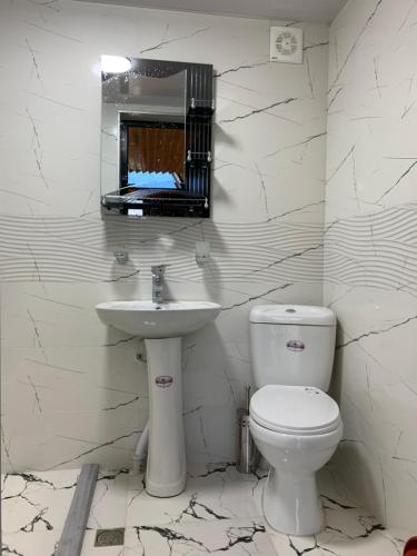 biała łazienka z toaletą i umywalką w obiekcie Eco house sunset w Kobuleti