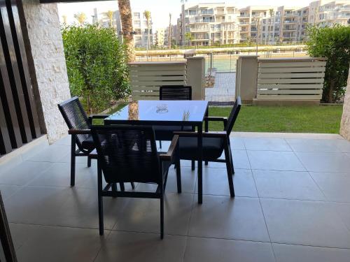 a table and chairs on a patio with a view at Marassi Marina Residences in El Alamein