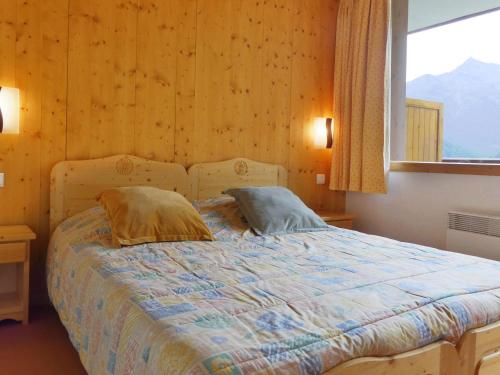 - une chambre avec un lit avec deux oreillers et une fenêtre dans l'établissement Charmant appart 2P, balcon sud, 5 pers, Méribel, animaux admis - FR-1-182-38, à Méribel