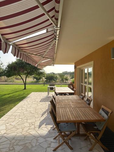 a patio with a table and chairs under awning at Villa Arzilla Sardegna in Alghero