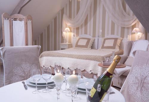 una habitación con una mesa con una botella de champán y copas en Côte d'Opale - La Ferme des Saules, en Millam