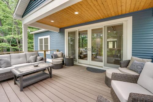 a patio with couches and a table on a deck at Dock and Yard Games Lakefront Michigan Getaway! in Free Soil