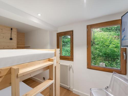 Cette chambre comprend un lit et une fenêtre. dans l'établissement Appartement rénové avec balcon - Centre de Courchevel 1850, proche remontées mécaniques - FR-1-564-87, à Courchevel