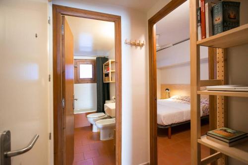un bagno con una camera da letto con letto e specchio di Salitres Increíbles vistas a 50m de la playa a Tamariu