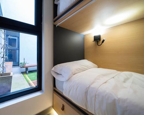 a small bedroom with a bed and a window at Dpaso hostel in Chantada