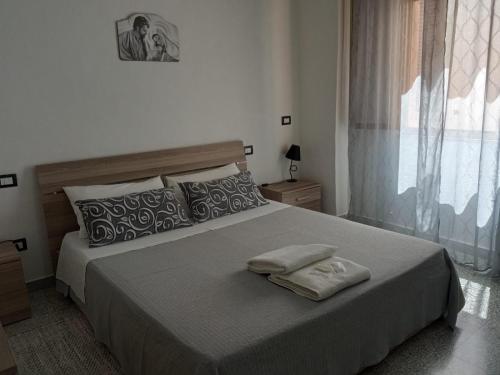 una camera da letto con un grande letto con due asciugamani di CASA "JOLANDA" - SANNICOLA, A 5 KM DA GALLIPOLI a Sannicola