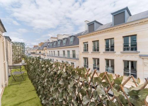 a row of buildings with a hedge of plants at Opera Residence in Paris