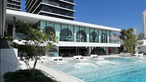 a large building with a swimming pool and lounge chairs at Luxury River View in Bangkok