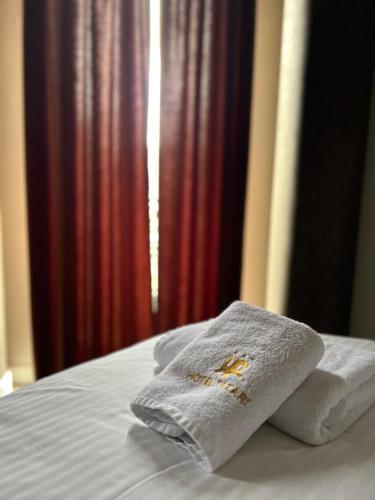 a bed with two towels sitting on top of it at Hotel Pazari & Apartments in Korçë
