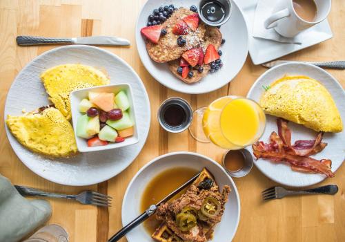 - une table en bois avec des assiettes de produits pour le petit-déjeuner dans l'établissement The Westin Resort & Spa, Whistler, à Whistler