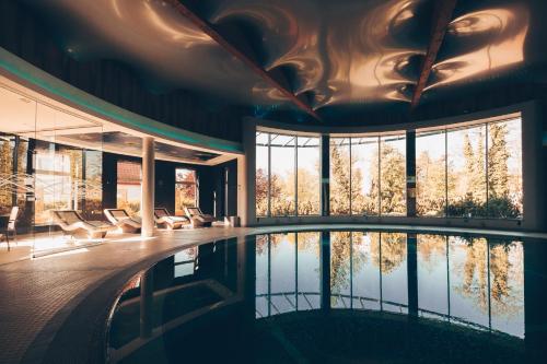 a swimming pool in a house with a large window at Hotel Wellness Medical Spa Unitral in Mielno