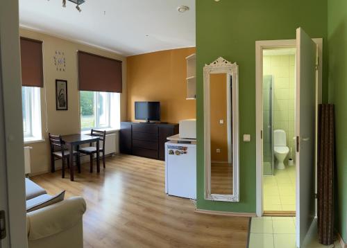 a kitchen and living room with green walls and a table at Mõisavälja 10 apartment in Rakvere