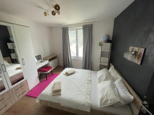 a bedroom with a bed and a desk and a window at Villa Nature in Sarajevo