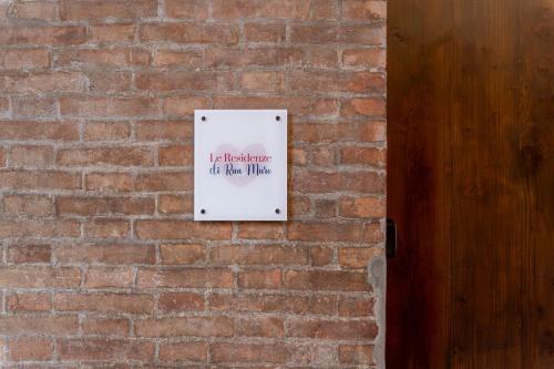 a sign on a brick wall next to a wooden door at FREE PARKING - Meraviglioso appartamento a Modena in Modena