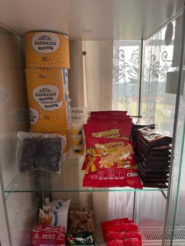 a shelf in a store filled with bags of food at Vila v Brdech s bazénem, infra saunou a vybavením in Malá Víska