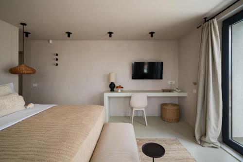 a bedroom with a bed and a desk with a tv at Euforia Retreat and Spa in Eforie Nord