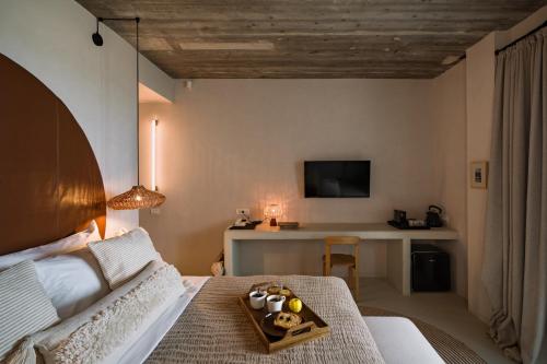 a bedroom with a bed and a table with a desk at Euforia Retreat and Spa in Eforie Nord