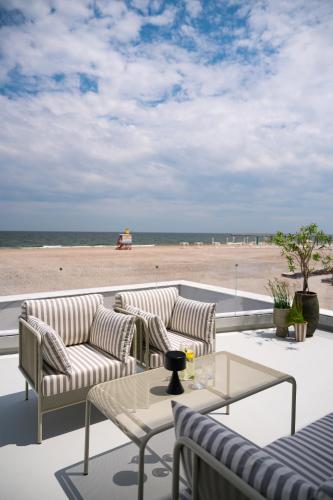 a patio with chairs and a table and the beach at Euforia Retreat and Spa in Eforie Nord