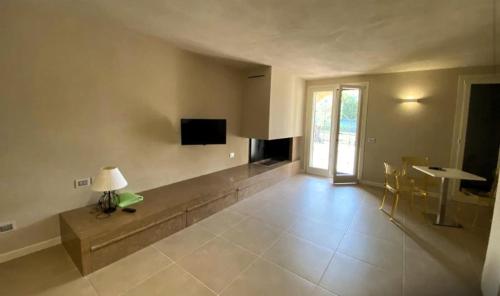 a living room with a television and a table and chairs at Vela di Soleville camere con e senza vista lago con ristorante & pizzeria in Sale Marasino
