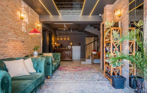 a living room with green couches and a brick wall at Twentyone By Vintage Hotel Collections in Tbilisi City