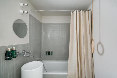 a bathroom with a tub and a shower curtain at Euforia Retreat and Spa in Eforie Nord