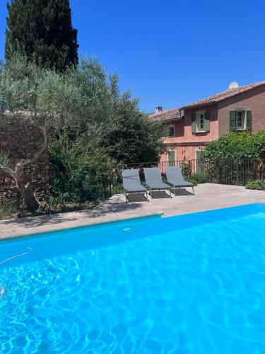 a pool with two benches next to a house at Les Hauts de Diane, CUERS var in Cuers