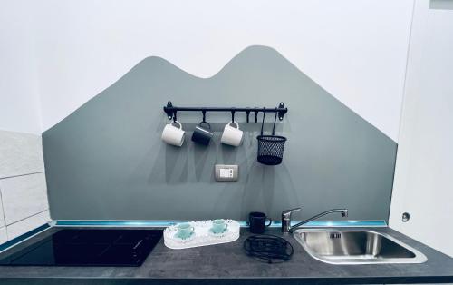 a kitchen counter with a sink and cups and a sink at La Casa di NAra in Naples